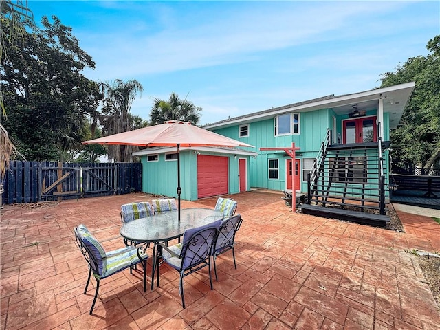 4230 Murano Rd, New Orleans, LA 70129 - fenced backyard featuring stairway, an outbuilding, a patio, ceiling fan, and outdoor dining space
