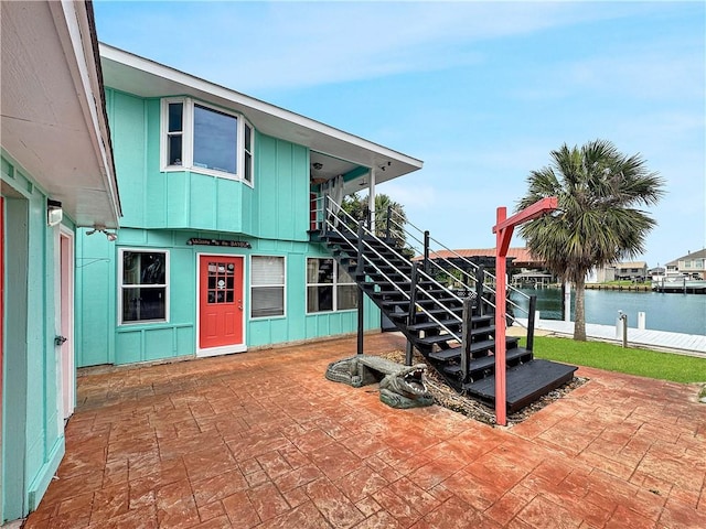 4230 Murano Rd, New Orleans, LA 70129 - view of front of house featuring stairs, board and batten siding, a patio area, and a water view