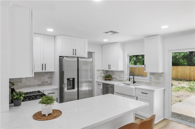 540 Ruth Dr, Westwego, LA 70094 - kitchen with appliances with stainless steel finishes, a peninsula, light stone counters, backsplash, and recessed lighting