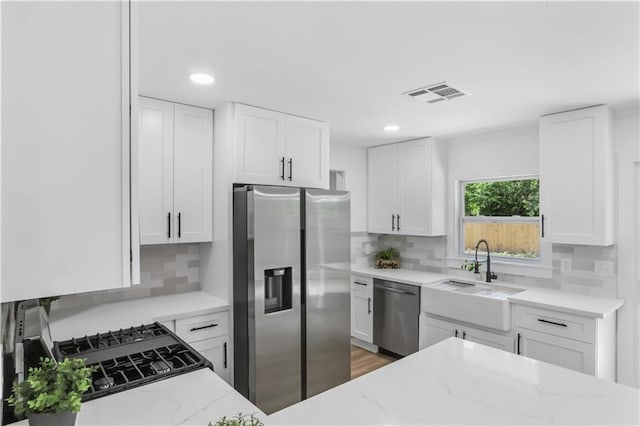 540 Ruth Dr, Westwego, LA 70094 - kitchen featuring stainless steel appliances, light stone counters, recessed lighting, white cabinets, and backsplash