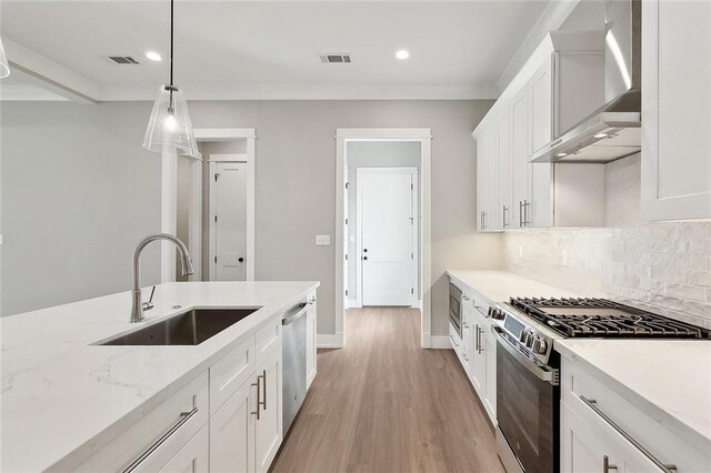72701 Robindale Dr, Covington, LA 70435 - kitchen with wall chimney exhaust hood, stainless steel appliances, recessed lighting, white cabinetry, and decorative backsplash