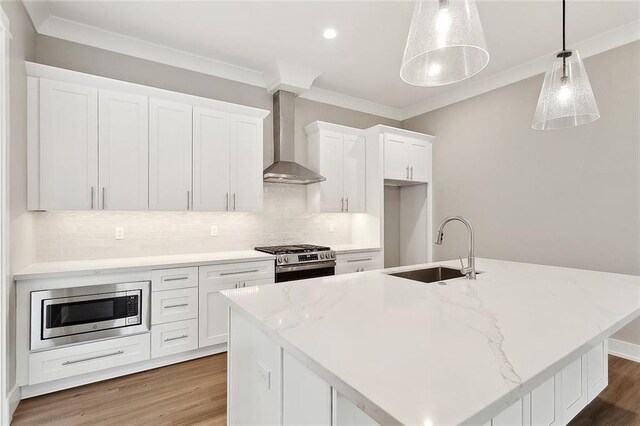 72701 Robindale Dr, Covington, LA 70435 - kitchen with wall chimney range hood, appliances with stainless steel finishes, crown molding, white cabinets, and backsplash