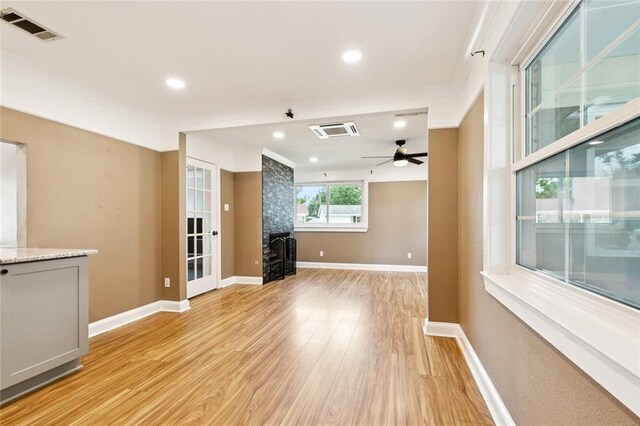 7032 Glenn St, Metairie, LA 70003 - unfurnished living room with light wood finished floors, ceiling fan, recessed lighting, and a wood stove
