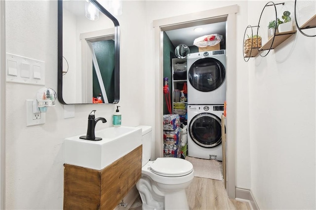 713 N Lester Ave, Metairie, LA 70003 - bathroom featuring stacked washer / drying machine, wood finished floors, and vanity