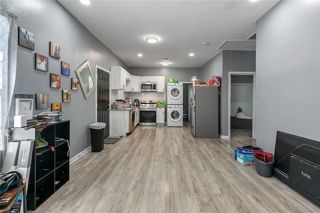 272 W Harrison St, Baton Rouge, LA 70802 - kitchen with stainless steel appliances, stacked washer / drying machine, light wood finished floors, white cabinetry, and recessed lighting