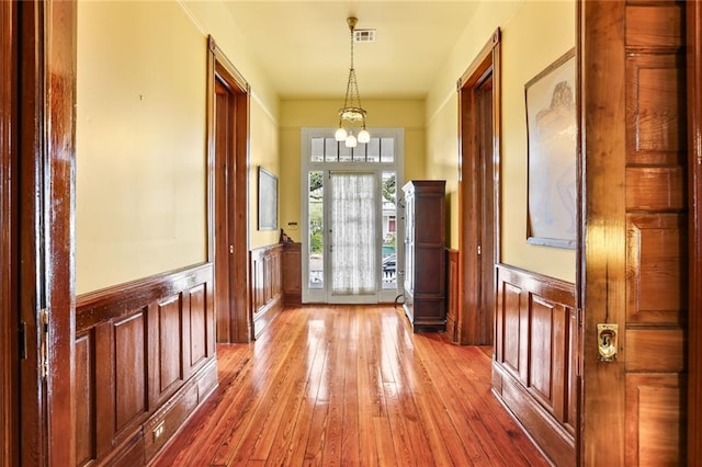 202 S Pierce St, New Orleans, LA 70119 - foyer entrance with wainscoting, a chandelier, wood-type flooring, and a decorative wall