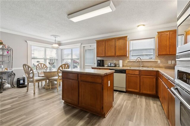 1111 Artesa Dr, Marrero, LA 70072 - kitchen featuring stainless steel appliances, a textured ceiling, a center island, brown cabinets, and crown molding
