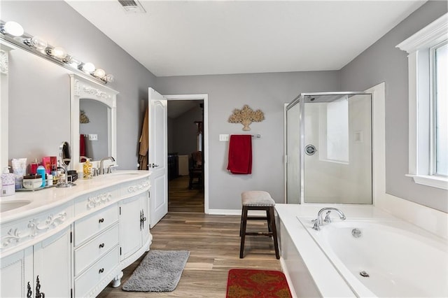 1111 Artesa Dr, Marrero, LA 70072 - bathroom featuring a garden tub, double vanity, a shower stall, and wood finished floors