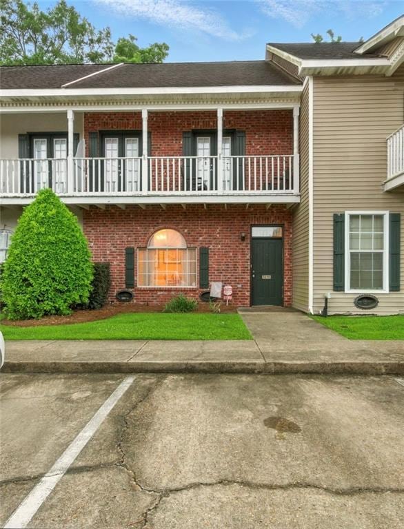 5191 Arlington Ct, Baton Rouge, LA 70820 - view of front of home featuring a balcony, brick siding, and uncovered parking