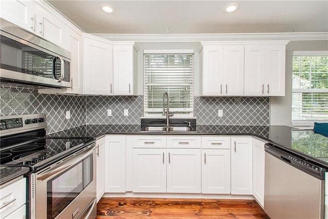 4108 Rayne Dr, New Orleans, LA 70122 - kitchen featuring stainless steel appliances, dark countertops, white cabinetry, recessed lighting, and light wood-type flooring