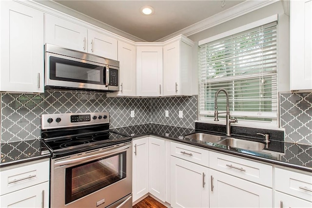 4108 Rayne Dr, New Orleans, LA 70122 - kitchen featuring stainless steel appliances, white cabinetry, ornamental molding, and decorative backsplash