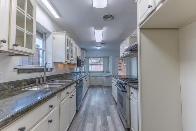 1729 High Ave, Metairie, LA 70001 - kitchen with stainless steel appliances, light wood finished floors, white cabinets, and dark stone countertops