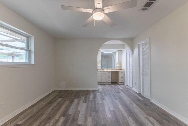 1729 High Ave, Metairie, LA 70001 - unfurnished bedroom featuring dark wood-type flooring, arched walkways, ensuite bath, and ceiling fan