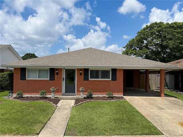 1904 Hall Ave, Metairie, LA 70003 - view of front of home featuring brick siding, a shingled roof, an attached carport, concrete driveway, and a front yard