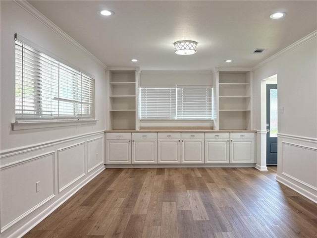 1904 Hall Ave, Metairie, LA 70003 - unfurnished dining area featuring ornamental molding, a decorative wall, healthy amount of natural light, wood finished floors, and recessed lighting