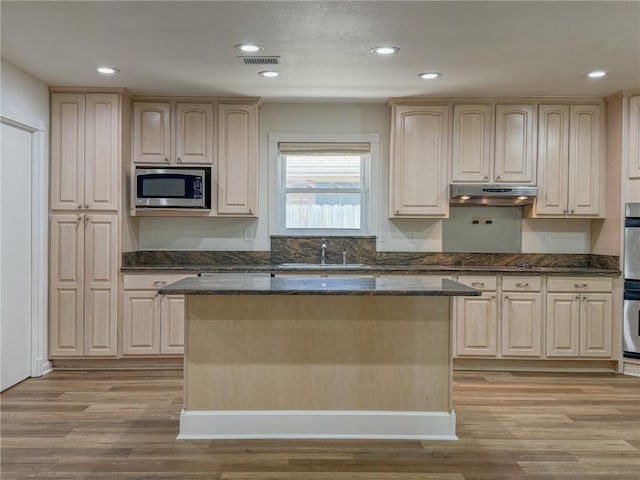 1904 Hall Ave, Metairie, LA 70003 - kitchen featuring appliances with stainless steel finishes, under cabinet range hood, light wood-style flooring, a kitchen island, and recessed lighting
