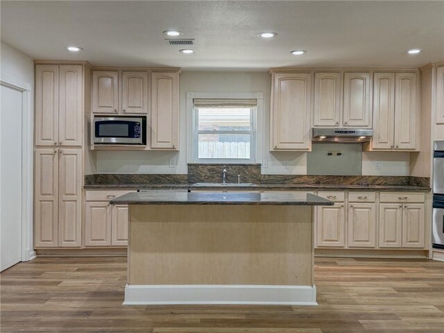 1904 Hall Ave, Metairie, LA 70003 - kitchen featuring appliances with stainless steel finishes, under cabinet range hood, light wood-style flooring, a kitchen island, and recessed lighting