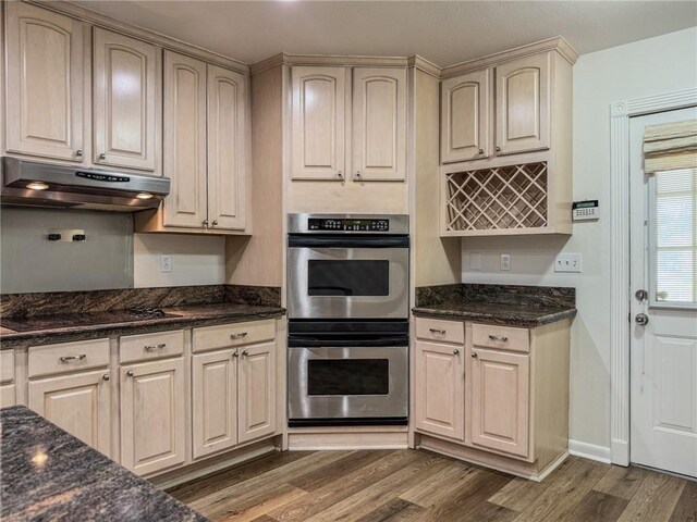 1904 Hall Ave, Metairie, LA 70003 - kitchen with double oven, under cabinet range hood, black electric stovetop, wood finished floors, and dark stone counters