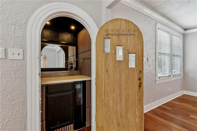 4752 Demontluzin St, New Orleans, LA 70122 - entrance foyer with a textured wall, wine cooler, wood finished floors, a textured ceiling, and arched walkways