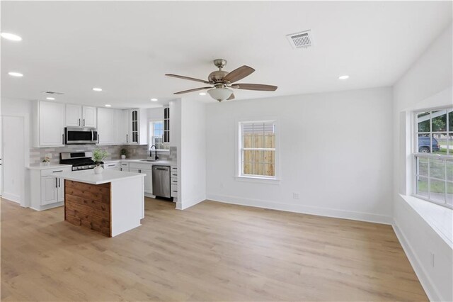 1909 Maryland Ave, Kenner, LA 70062 - kitchen featuring appliances with stainless steel finishes, recessed lighting, tasteful backsplash, light countertops, and glass insert cabinets