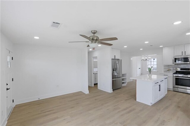 1909 Maryland Ave, Kenner, LA 70062 - kitchen featuring stainless steel appliances, light countertops, light wood-style floors, white cabinets, and a ceiling fan