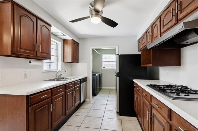 4517 Purdue Dr, Metairie, LA 70003 - kitchen featuring appliances with stainless steel finishes, separate washer and dryer, a ceiling fan, under cabinet range hood, and light countertops