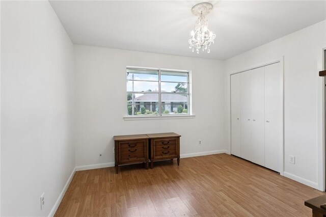 4517 Purdue Dr, Metairie, LA 70003 - unfurnished bedroom with a chandelier, light wood-type flooring, and a closet