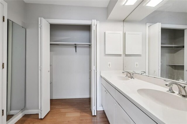 4517 Purdue Dr, Metairie, LA 70003 - bathroom featuring double vanity, wood finished floors, and a walk in closet
