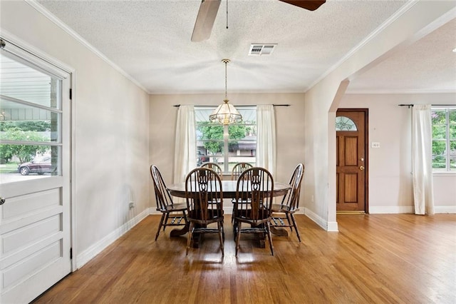 508 Beverly Garden Dr, Metairie, LA 70005 - dining area with wood finished floors, ceiling fan, a textured ceiling, crown molding, and arched walkways