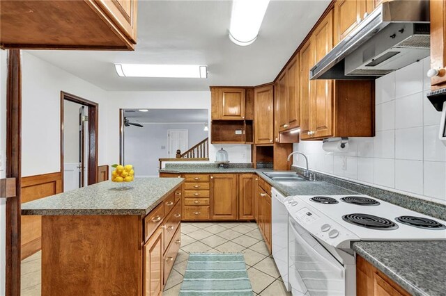 174 Celia Dr, Luling, LA 70070 - kitchen with white appliances, under cabinet range hood, light tile patterned flooring, brown cabinets, and a kitchen island
