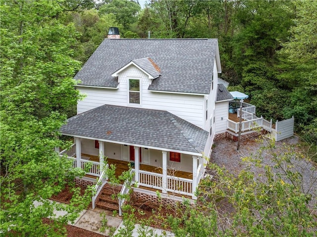 71434 Saint Joseph St, Abita Springs, LA 70420 - view of front of house featuring a shingled roof, a porch, a chimney, and a wooded view