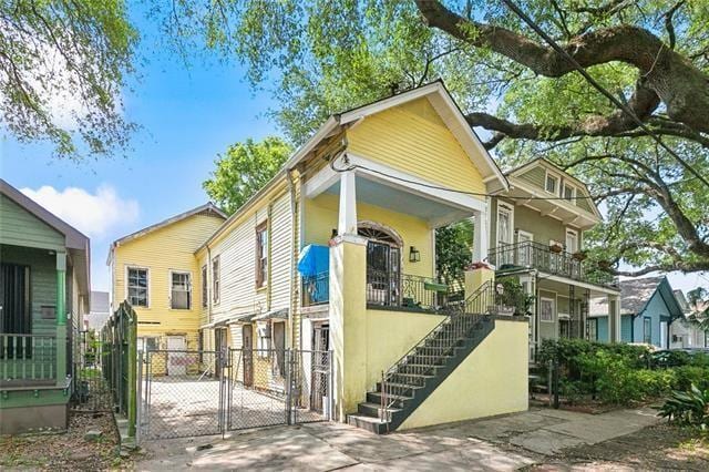 1534 N Dorgenois St, New Orleans, LA 70119 - shotgun-style home with a gate, stairs, and a porch