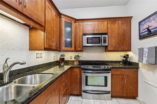 333 Girod St Unit 304, New Orleans, LA 70130 - kitchen with appliances with stainless steel finishes, tasteful backsplash, dark stone countertops, and light tile patterned flooring