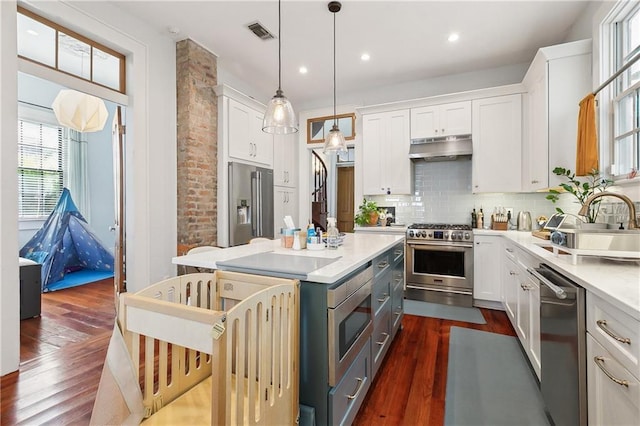 422 Alix St, New Orleans, LA 70114 - kitchen with premium appliances, under cabinet range hood, dark wood-style flooring, white cabinetry, and recessed lighting