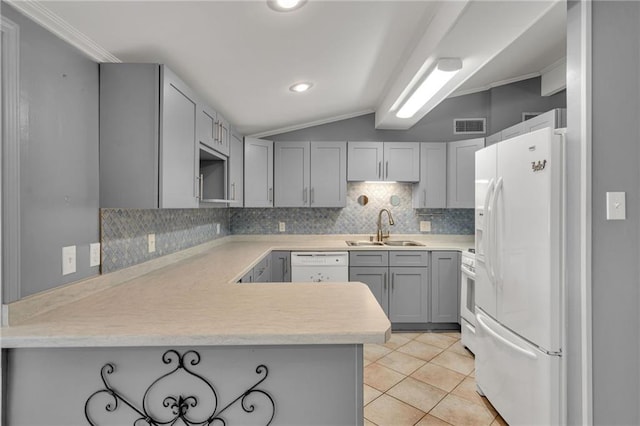 7 Albert Ct, Metairie, LA 70003 - kitchen featuring white appliances, gray cabinetry, tasteful backsplash, lofted ceiling, and a peninsula