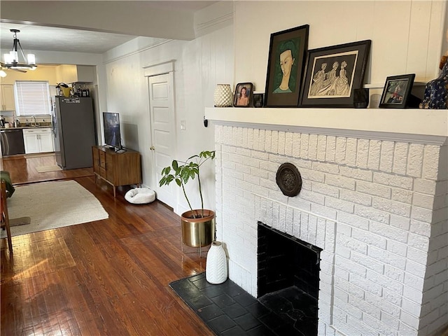7935 Fig St, New Orleans, LA 70125 - living room with dark wood finished floors, a fireplace, and a chandelier