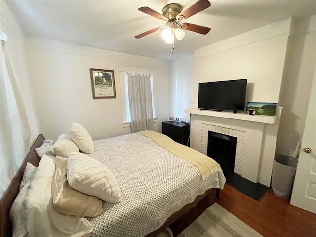 7935 Fig St, New Orleans, LA 70125 - bedroom with wood finished floors, a brick fireplace, and a ceiling fan