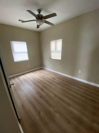 1317-1919 S Genois St, New Orleans, LA 70125 - unfurnished room featuring healthy amount of natural light, wood finished floors, and ceiling fan