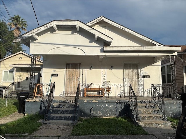 1317-1919 S Genois St, New Orleans, LA 70125 - shotgun-style home featuring stucco siding and covered porch
