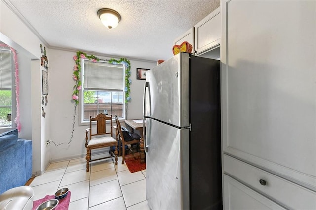 1500 Shirley Dr, New Orleans, LA 70114 - kitchen featuring freestanding refrigerator, a textured ceiling, and light tile patterned flooring