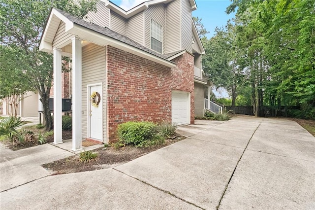 521 Spartan Dr Unit 10207, Slidell, LA 70458 - view of home's exterior featuring brick siding, concrete driveway, a garage, and roof with shingles
