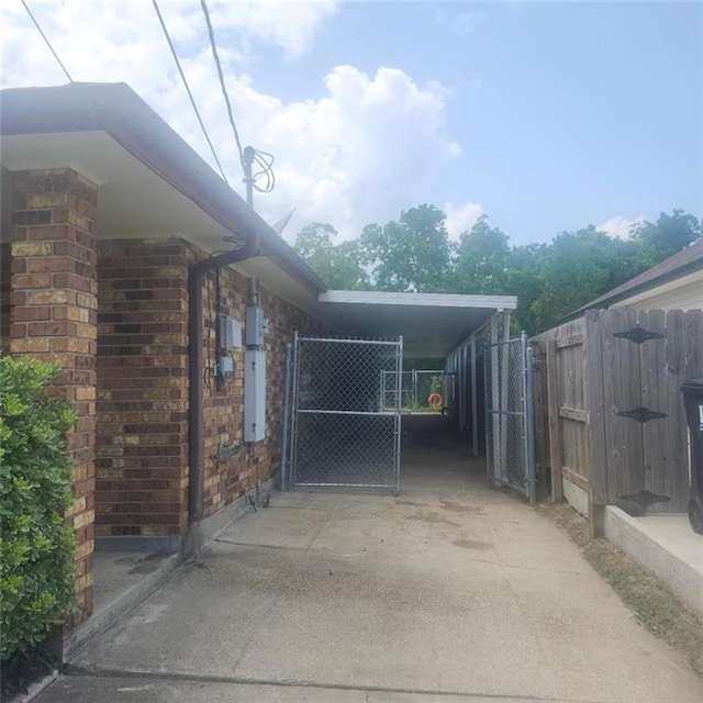 3020 Maureen Ln, Meraux, LA 70075 - view of property exterior with a gate, brick siding, driveway, and a carport