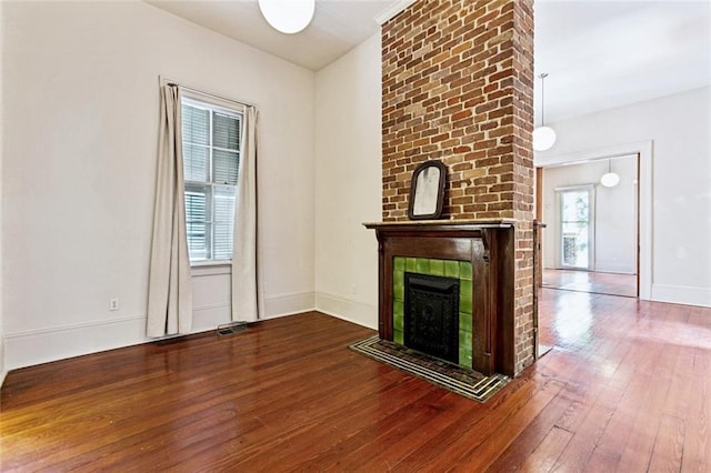 3354 Esplanade Ave, New Orleans, LA 70119 - unfurnished living room featuring hardwood / wood-style floors and a brick fireplace