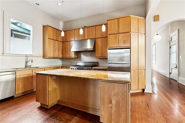 3354 Esplanade Ave, New Orleans, LA 70119 - kitchen featuring wall chimney range hood, stainless steel appliances, dark wood-style floors, and light stone countertops