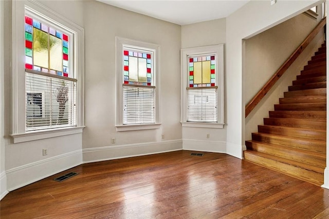 3354 Esplanade Ave, New Orleans, LA 70119 - empty room with wood finished floors, plenty of natural light, and stairs