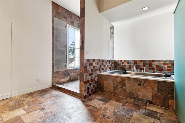 3354 Esplanade Ave, New Orleans, LA 70119 - full bath with a garden tub, stone tile flooring, and tiled shower