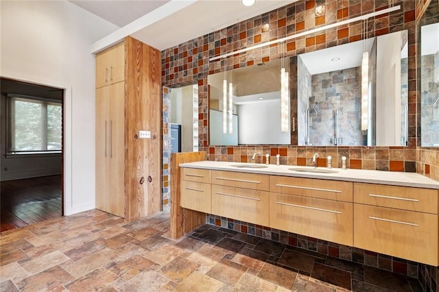 3354 Esplanade Ave, New Orleans, LA 70119 - full bath with double vanity, stone tile flooring, and decorative backsplash
