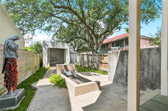 3354 Esplanade Ave, New Orleans, LA 70119 - fenced backyard featuring a storage unit and a patio area
