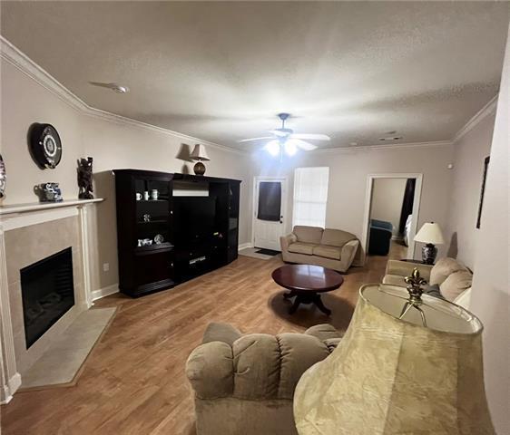 40145 Taylors Trl Unit 304, Slidell, LA 70461 - living room with wood finished floors, ornamental molding, ceiling fan, and a high end fireplace