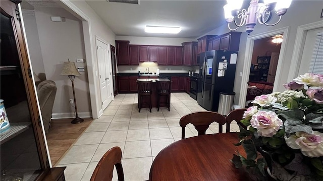 40145 Taylors Trl Unit 304, Slidell, LA 70461 - kitchen with black fridge, a chandelier, a kitchen island, and light tile patterned floors